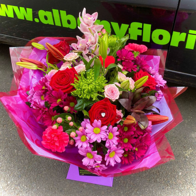 Cerise Crush - A bold mix of hot pink flowers, lilies and seasonal textures arranged in a striking wrapped bouquet by Albany Florists. Vibrant, stylish and full of personality.