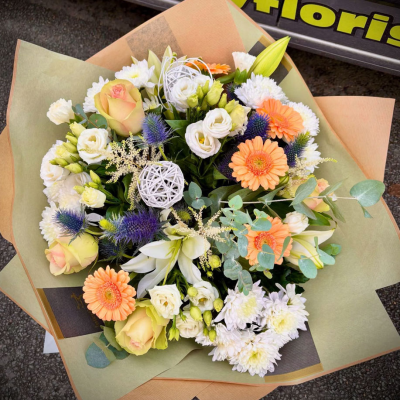 Country Garden - A textured bouquet featuring thistles, lilies, peach germini and seasonal flowers arranged by Albany Florists in a relaxed garden style with natural beauty throughout.