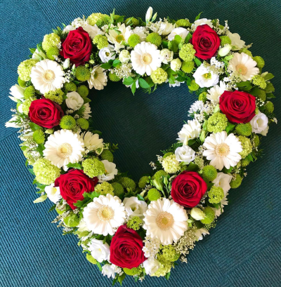 Heart Tribute - A beautifully crafted heart-shaped funeral wreath symbolising everlasting love, treasured memories, and heartfelt remembrance. Designed in a timeless palette with rich accents and soft, elegant textures, this tribute offers a meaningful expression of sympathy and devotion. Thoughtfully arranged to honour a cherished life, it serves as a touching farewell and a lasting symbol of love that remains forever in the hearts of family and friends.